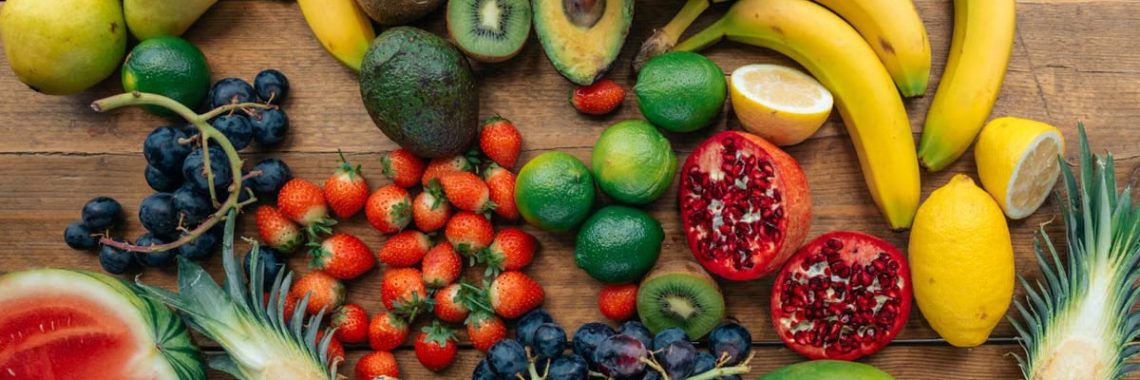 A vibrant display of fresh fruits including watermelon, bananas, grapes, and more on a wooden surface.
